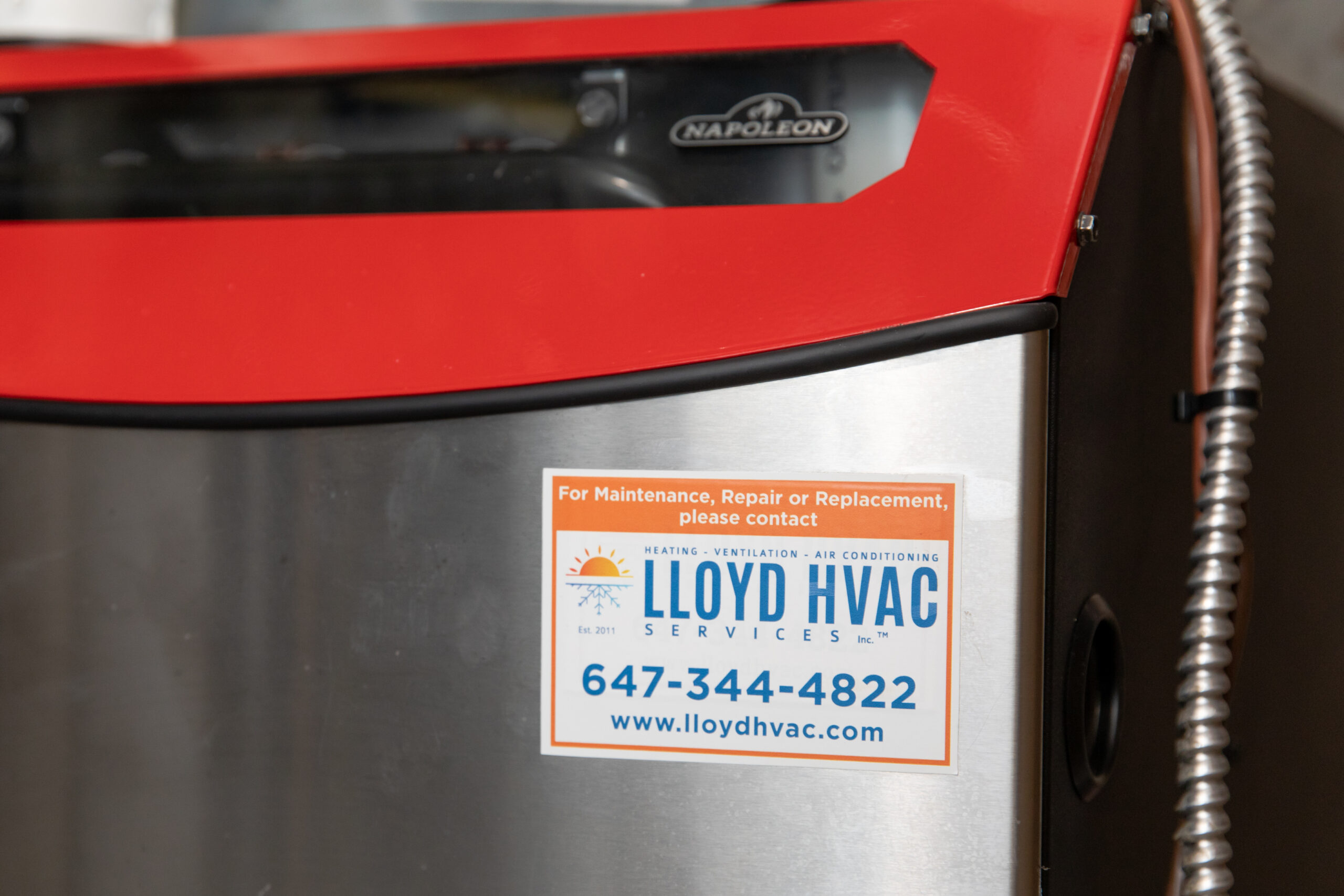 Furnace blowing cold air? A high-efficiency furnace with a Lloyd HVAC service label after repair